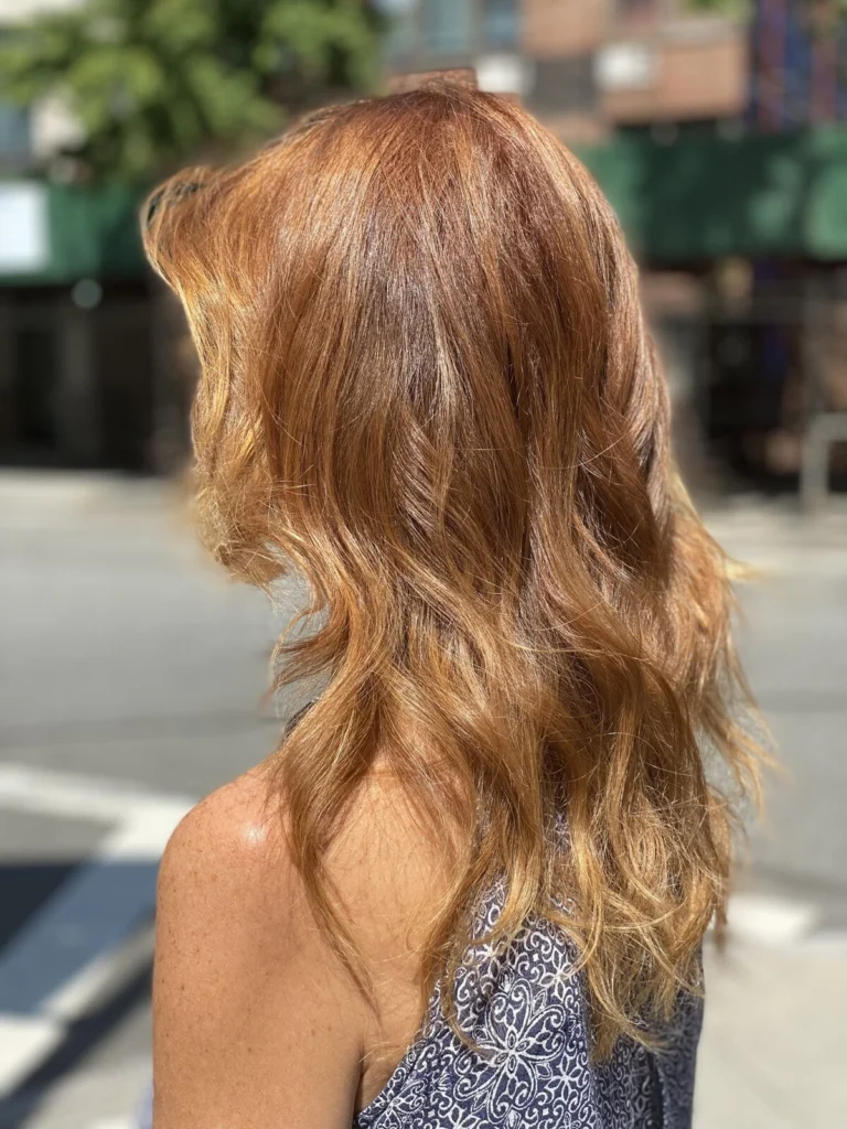 Layered copper hair with soft waves, photographed on the street outside
